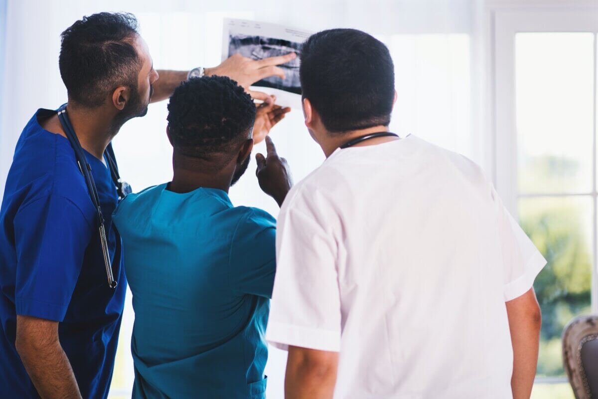 Three Person Looking at X-ray Result