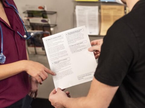 woman in black shirt holding white printer paper