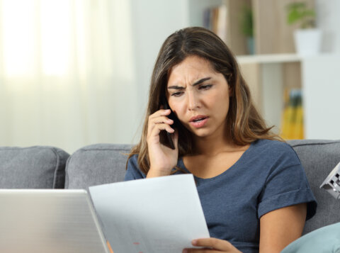 woman on phone looking at paperwork