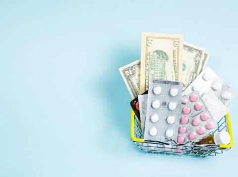 a shopping cart filled with pills and money